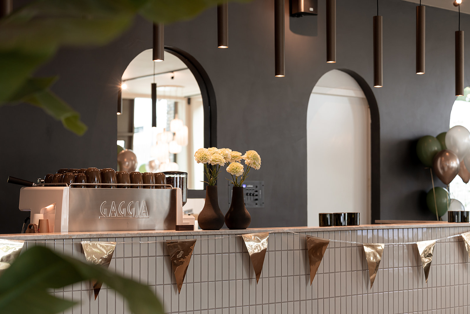 Detail van de koffiebar bij Bij Herbert met Gaggia-machine en witte anjers